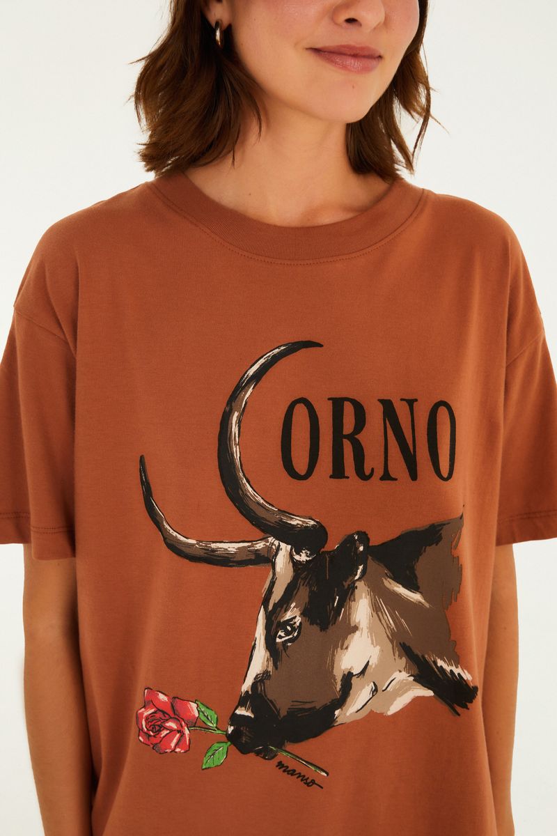 Detalle del estampado de toro y rosa en la camisa marrón.
