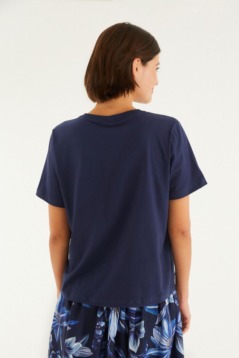 Vista posterior de la camiseta azul oscuro con diseño sencillo y elegante.