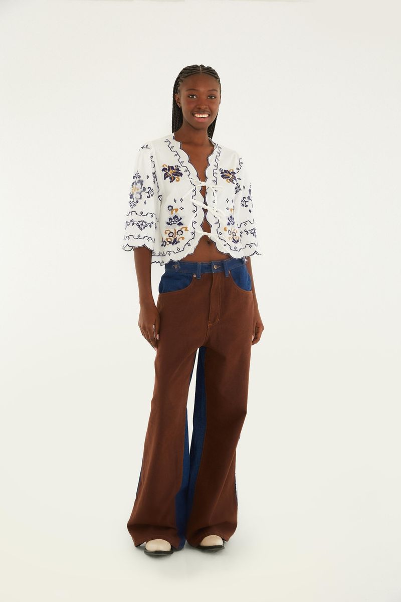 Imagen mostrando la bata bordada siendo usada con pantalón marrón y azul.