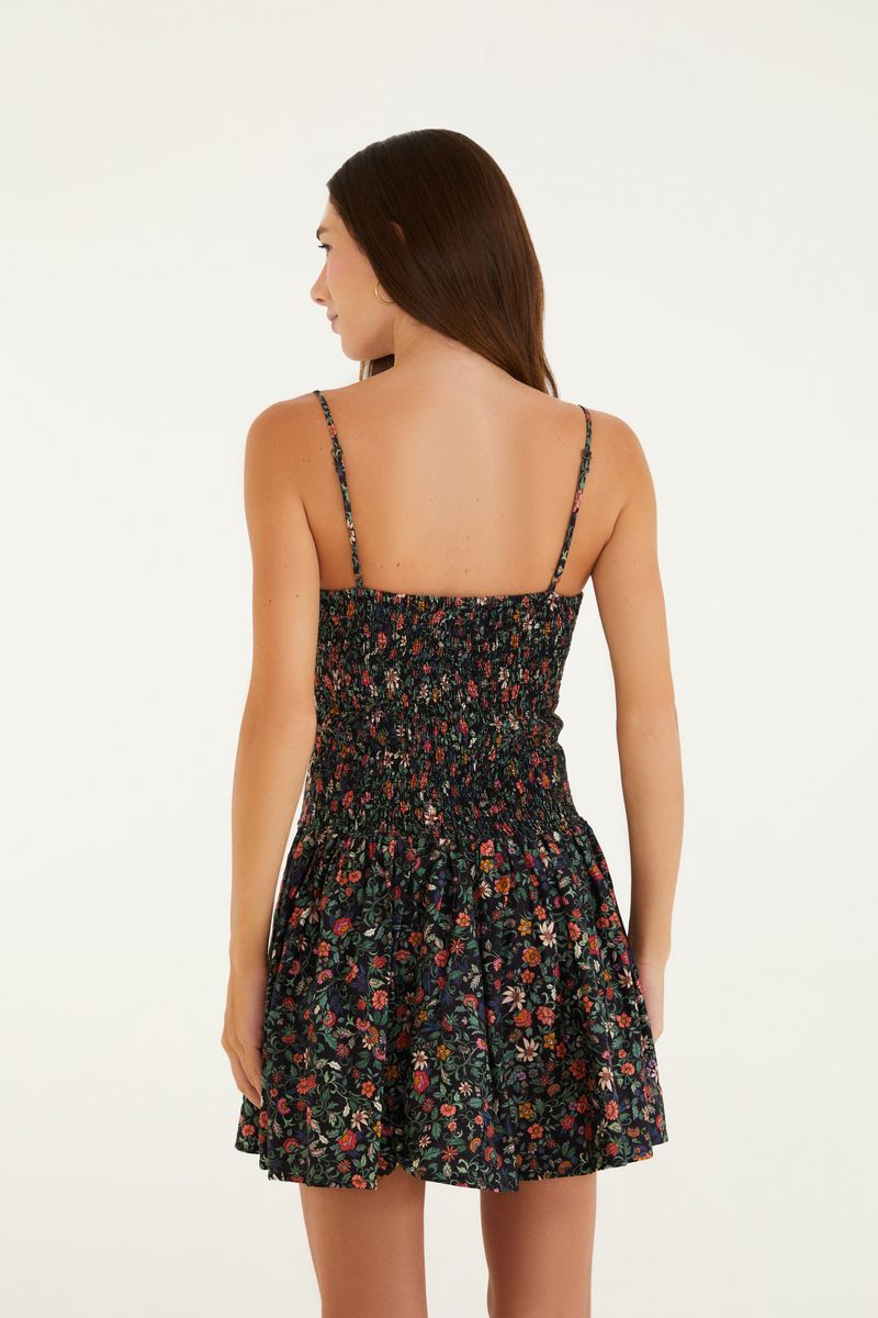 Imagen del vestido corto con estampado floral, tirantes delgados y escote redondo, visto de espaldas.