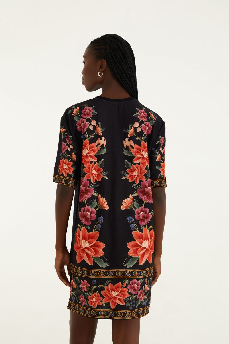 Vestido tipo camiseta con estampado floral vibrante sobre fondo negro, vista trasera.