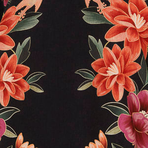Detalle del estampado floral vibrante sobre fondo negro del vestido.