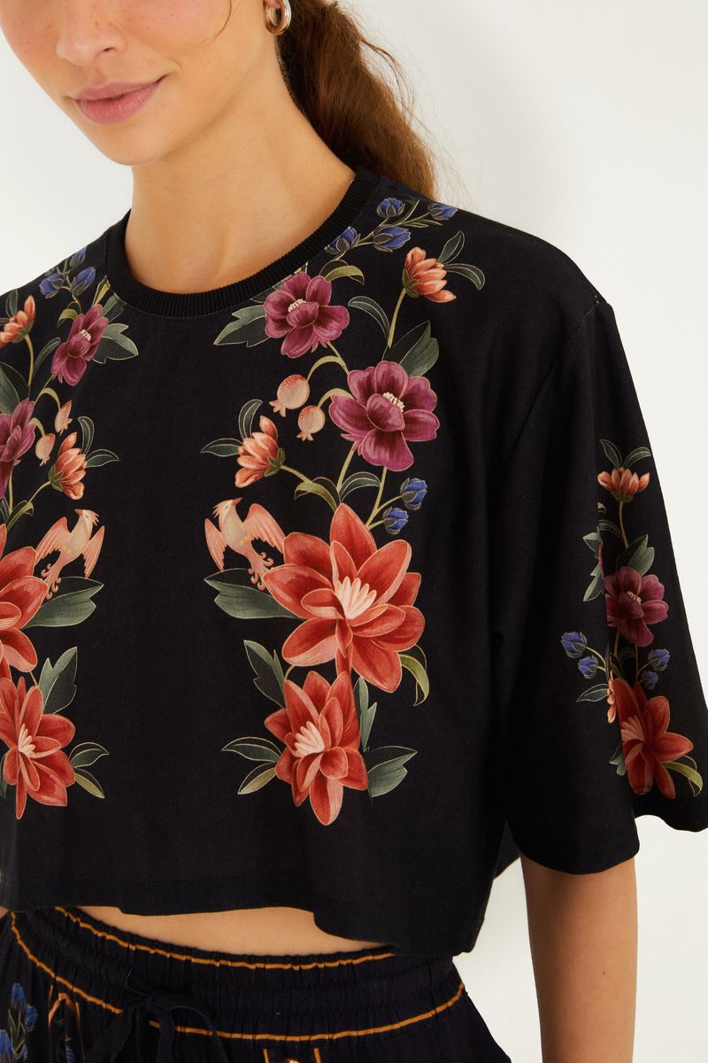 Detalle del escote y estampados florales en la parte frontal de la camiseta.
