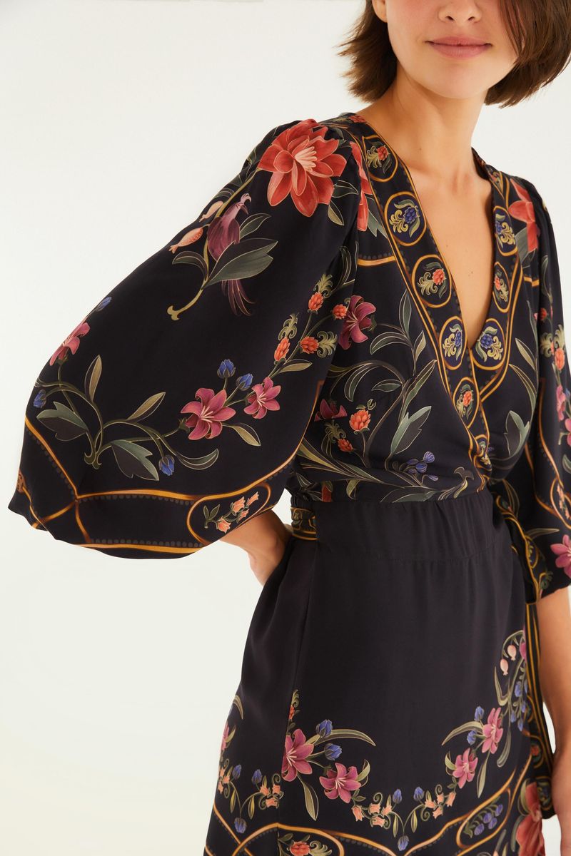 Detalle del escote en V y estampado floral del vestido corto.