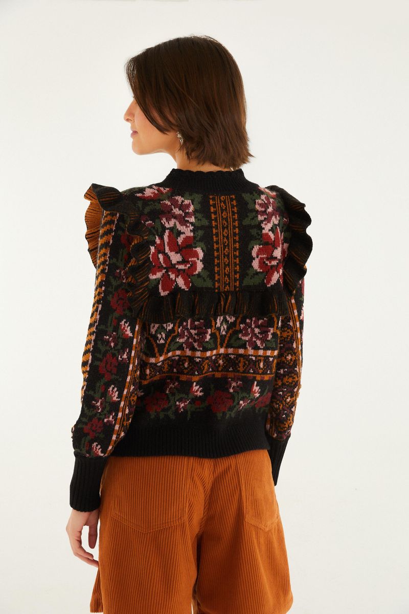 Vista trasera de la blusa de tejido artesanal con cuello alto y estampado floral ornamentado.