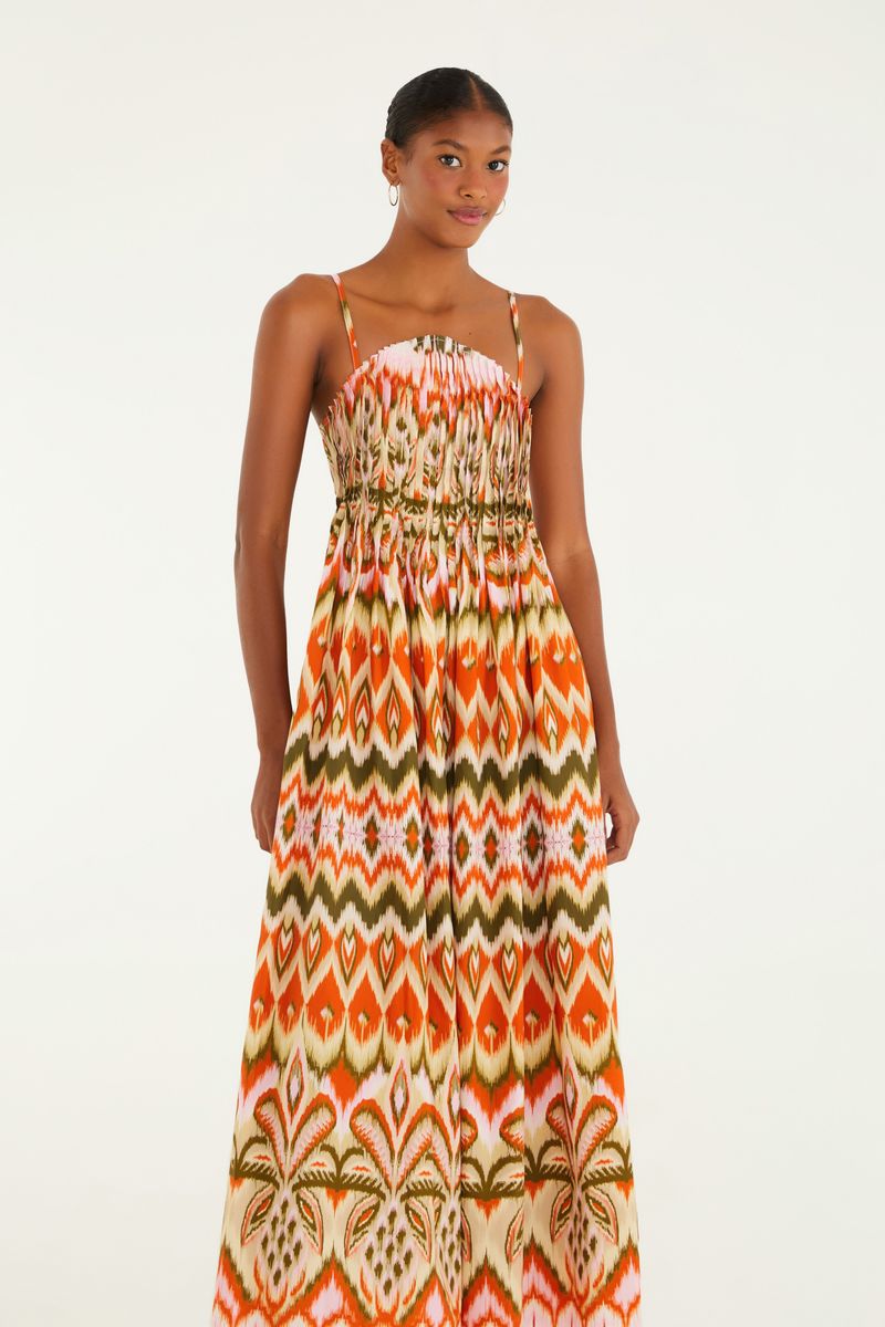 Imagen de un vestido largo con tirantes, estampado con patrón Ikat en tonos naranja, verde y blanco, visto de frente.