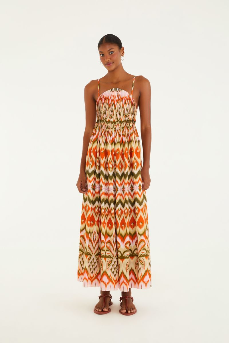 Imagen de un vestido largo con tirantes, estampado con patrón Ikat en tonos naranja, verde y blanco, visto desde atrás.