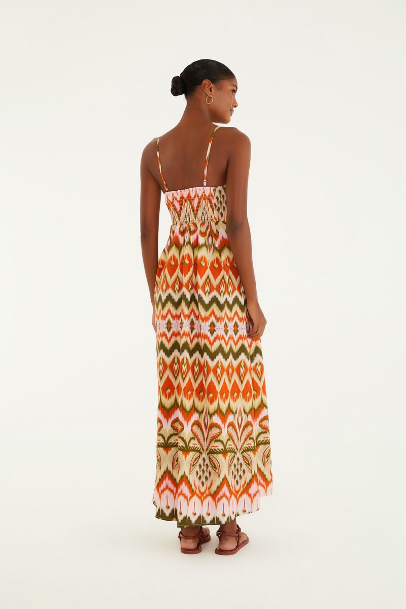 Acercamiento al estampado Ikat del vestido, destacando los detalles en naranja, verde y blanco.