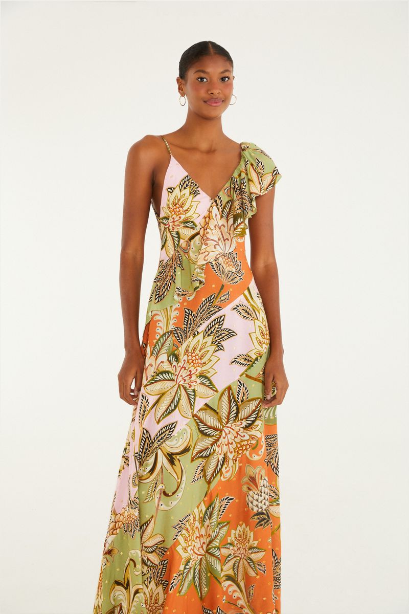 Vestido largo con estampado floral en tonos verdes, naranjas y rosados, con volado en el hombro y escote asimétrico.