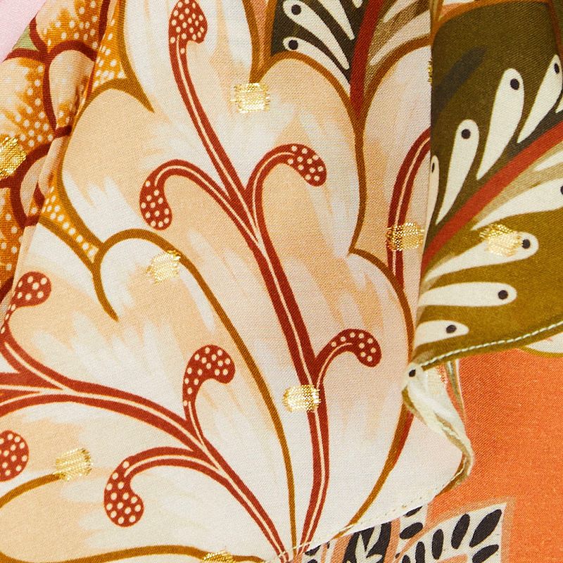 Detalle del borde del vestido con estampado floral y acabado en volado.