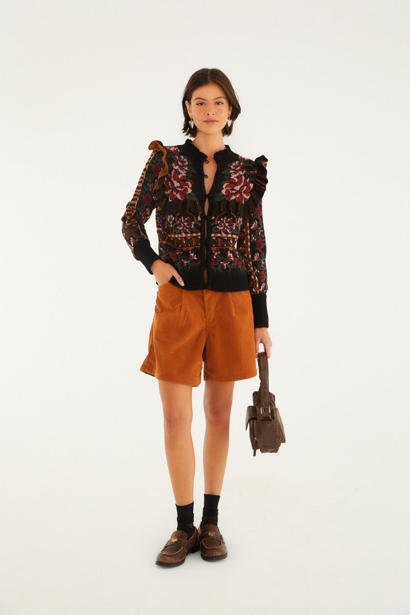 Imagen de una modelo luciendo un short de pana marrón, combinado con una blusa estampada y zapatos marrones.