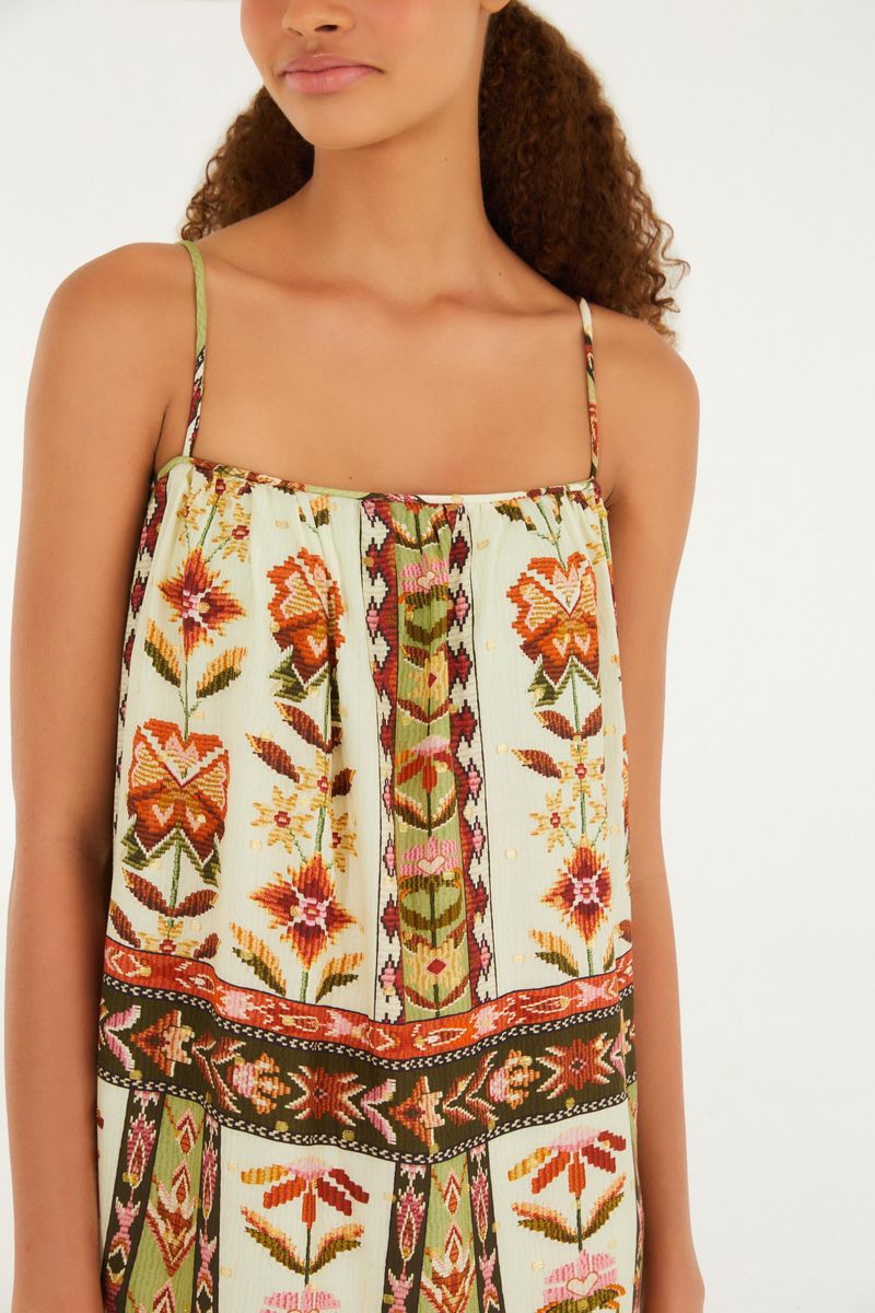 Imagen de un acercamiento del vestido estampado, destacando el escote recto y los detalles florales y geométricos.