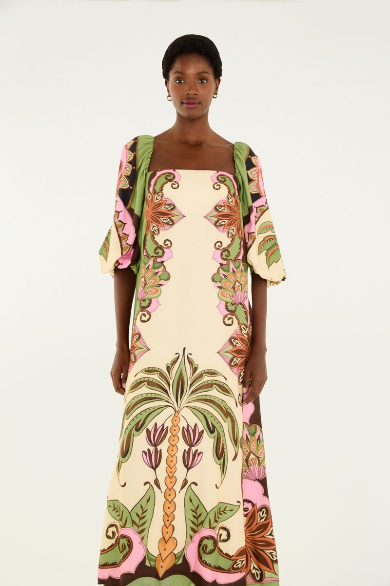Vestido largo con estampado botánico en tonos de verde, rosa y beige, visto de espaldas.