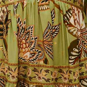 Detalle del estampado floral del vestido, con elementos botánicos y colores vibrantes.
