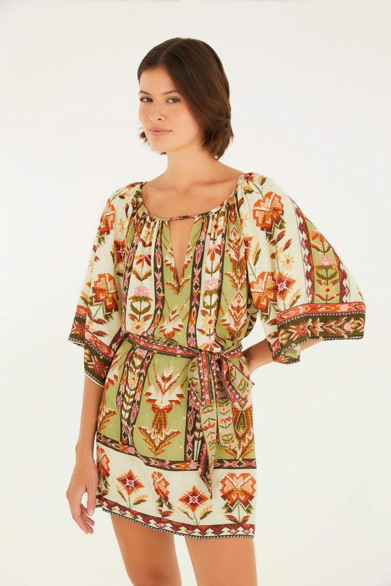 Vestido corto con estampado vibrante, detalles florales y geométricos, y mangas amplias.