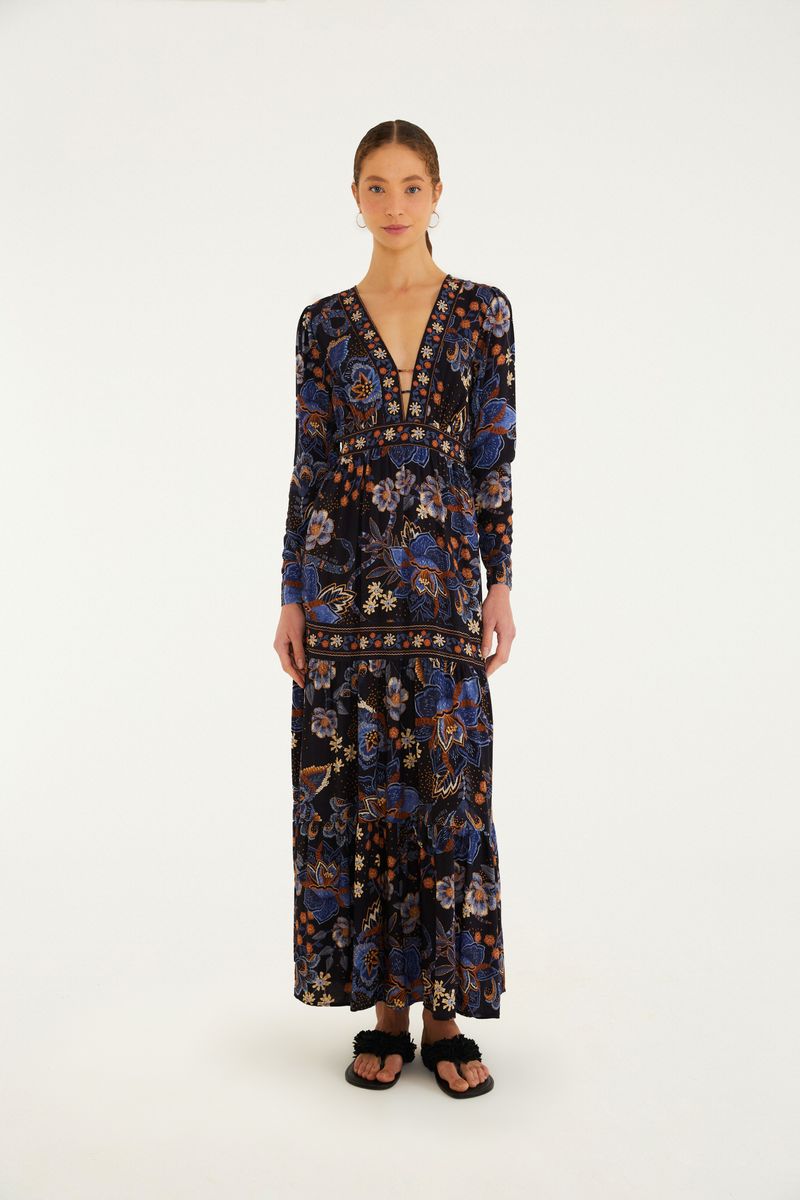 Vestido largo con mangas largas y estampado floral en tonos de azul y naranja, visto de frente.