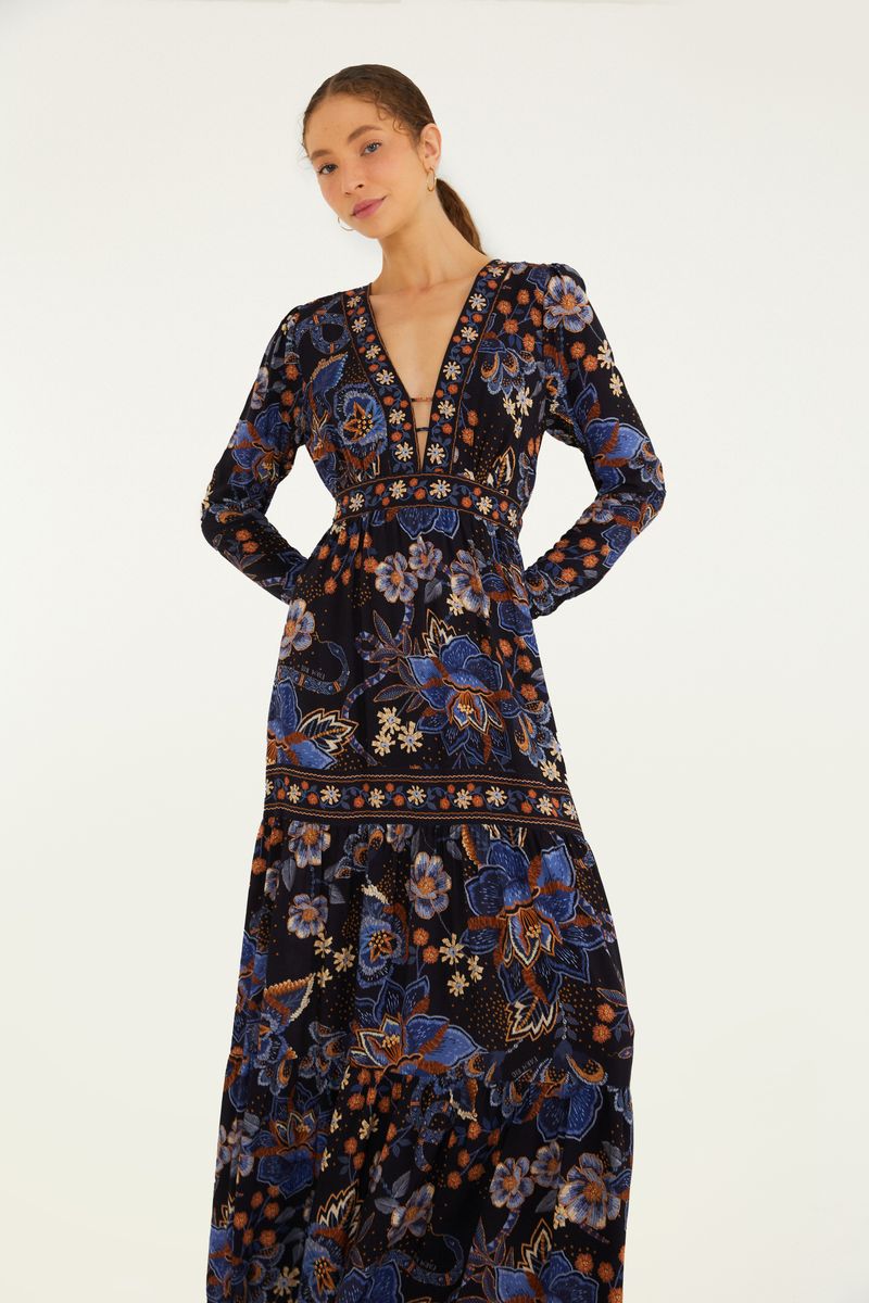 Vestido largo con mangas largas y estampado floral en tonos de azul y naranja, visto de espaldas.