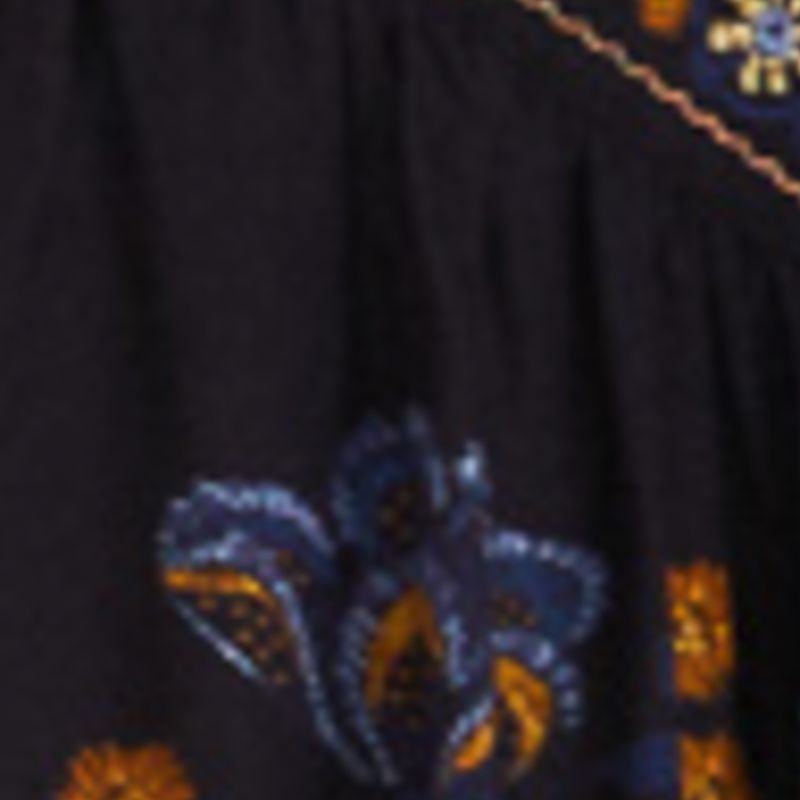 Primer plano del estampado floral del vestido mostrando detalles en azul y naranja.