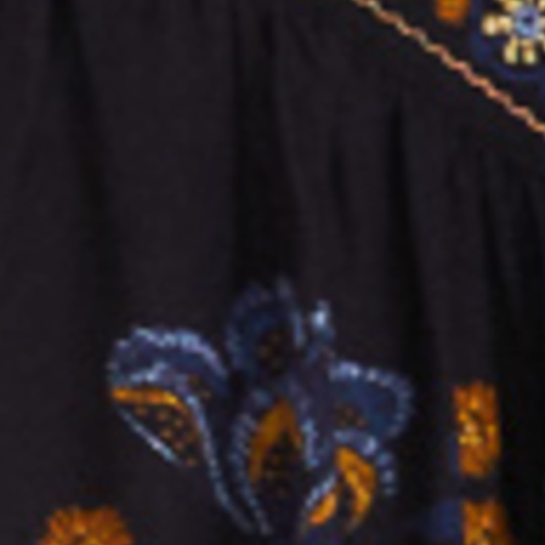 Primer plano del estampado floral del vestido mostrando detalles en azul y naranja.