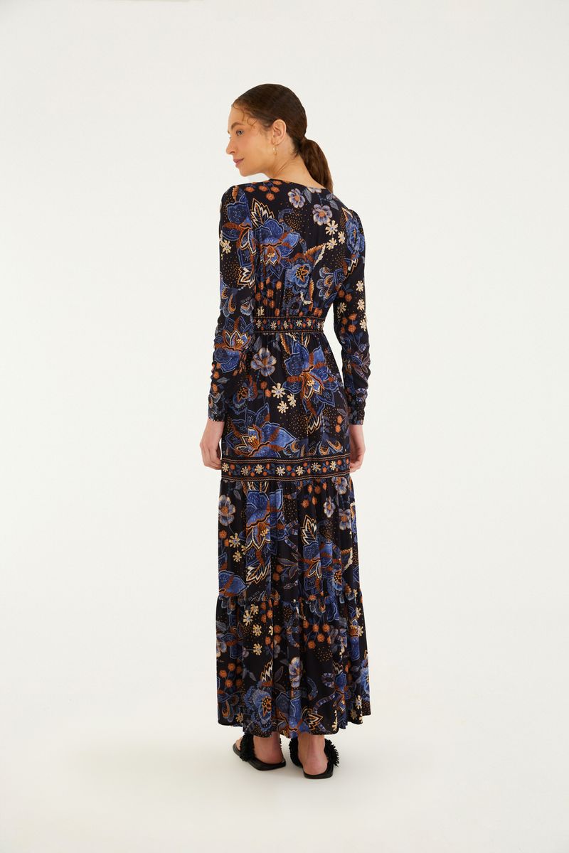 Vista lateral del vestido largo con estampado floral, destacando el ajuste en la cintura.