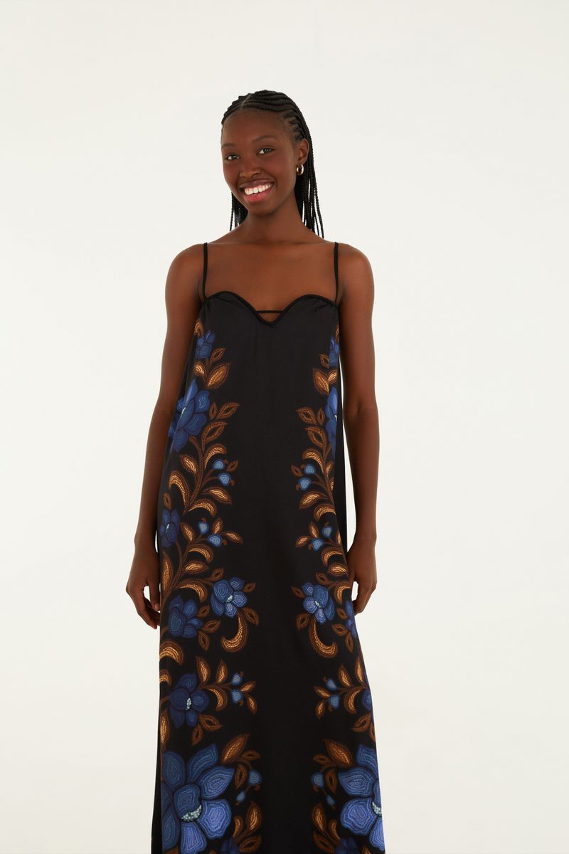 Vestido largo floral con tirantes finos, fondo negro y estampado de flores azules y hojas marrones.