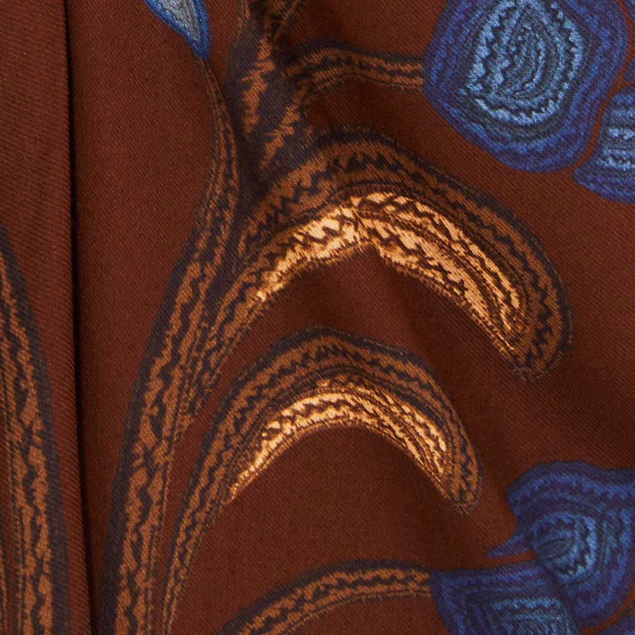 Acercamiento al estampado floral en tonos de azul y marrón del tejido del vestido.