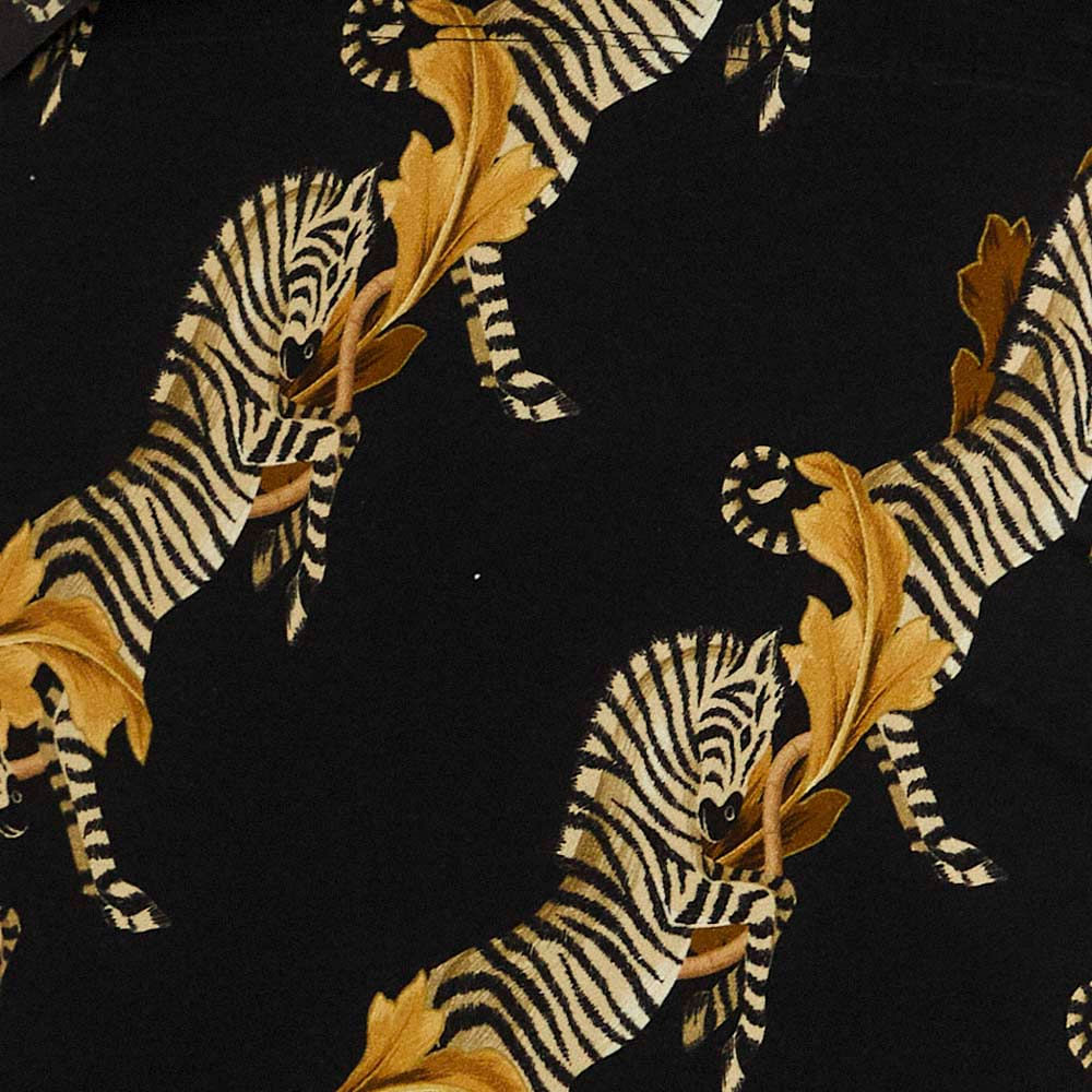 Primer plano del estampado de cebra en fondo oscuro de la falda midi.
