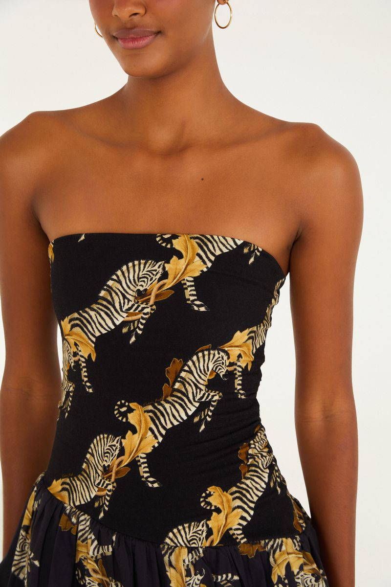 Primer plano del corsé del vestido con estampado de cebra sobre fondo negro.