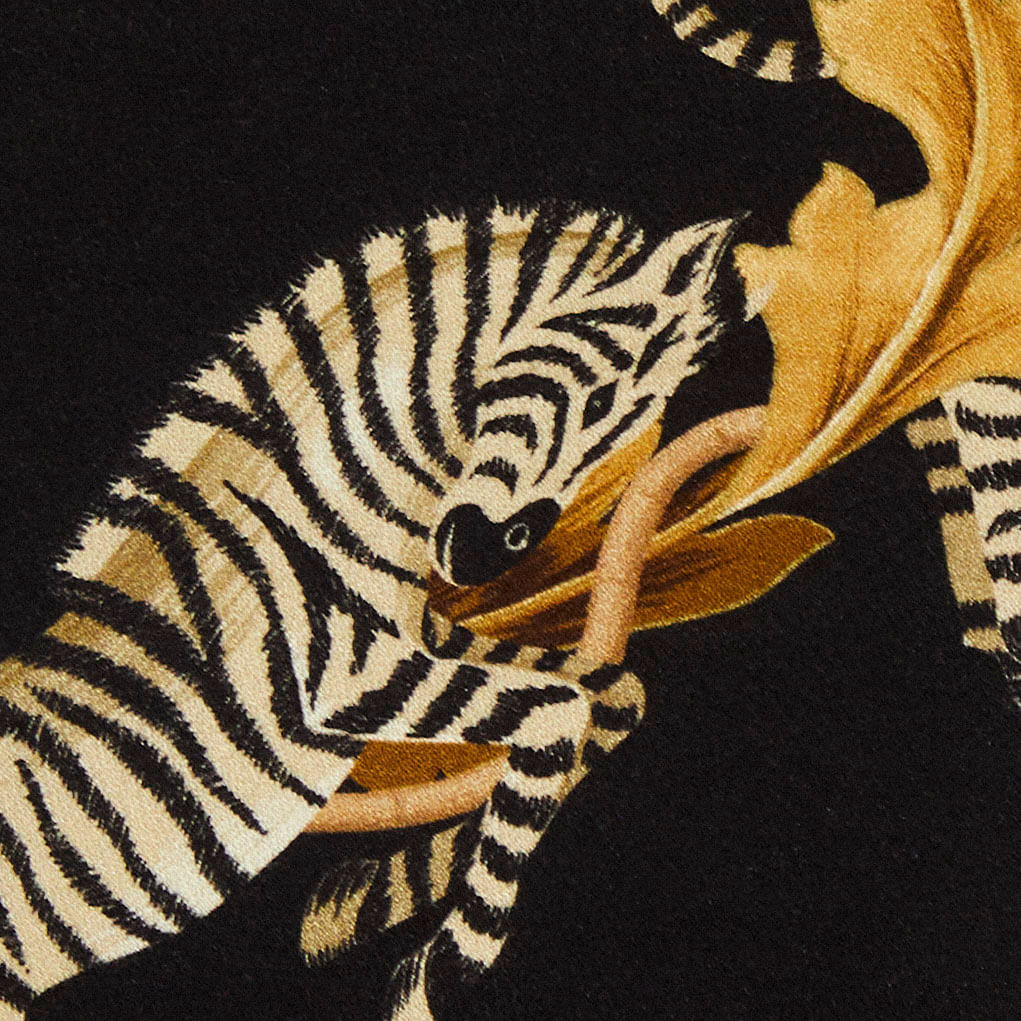 Detalle del estampado de cebra sobre fondo negro del vestido.