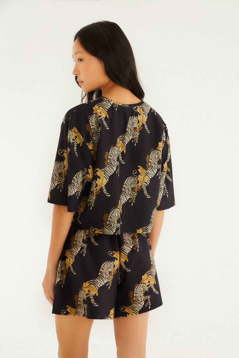 Vista trasera del conjunto de short y blusa estampados con tema de cebra, destacando el diseño y el estampado.