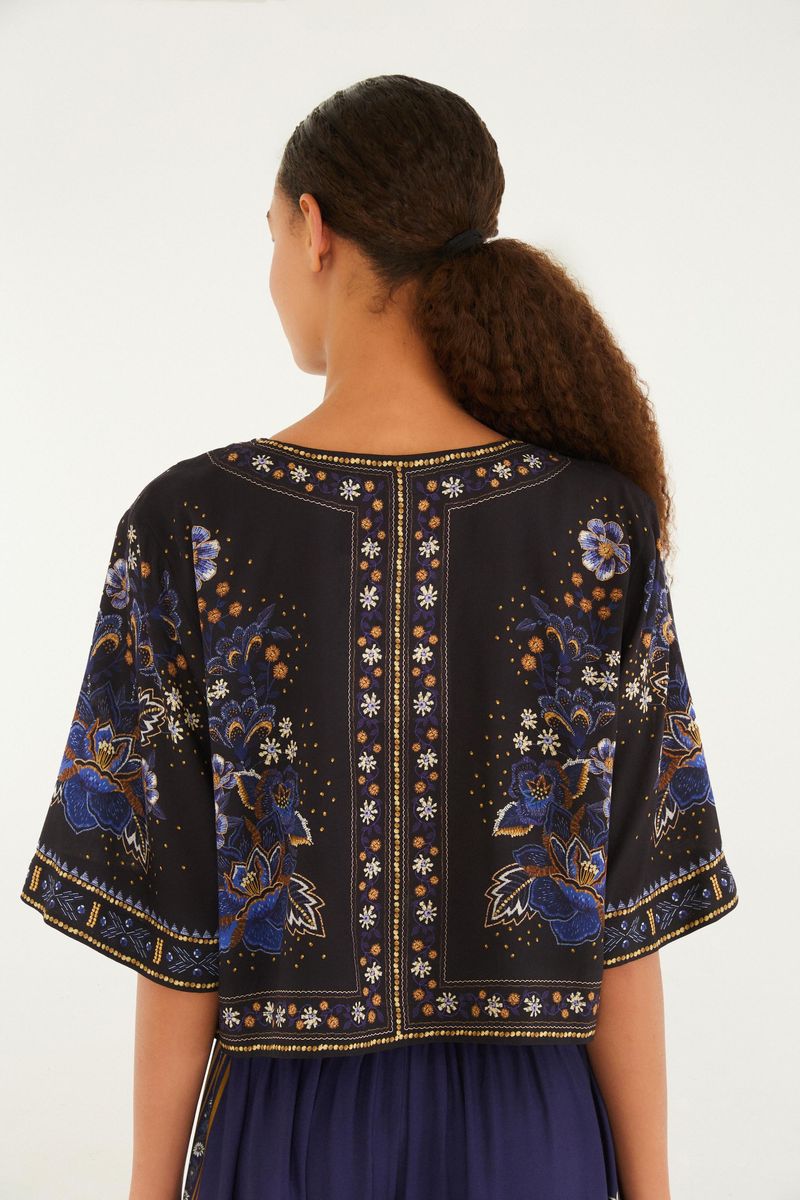 Vista trasera de la camiseta cropped floral, exhibiendo el patrón simétrico y el estilo moderno.