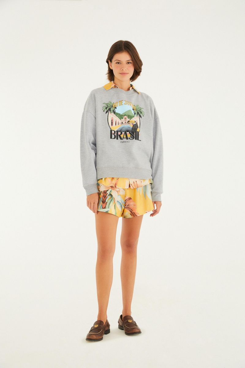 Modelo usando el moletón gris estampado, combinado con shorts con diseño.
