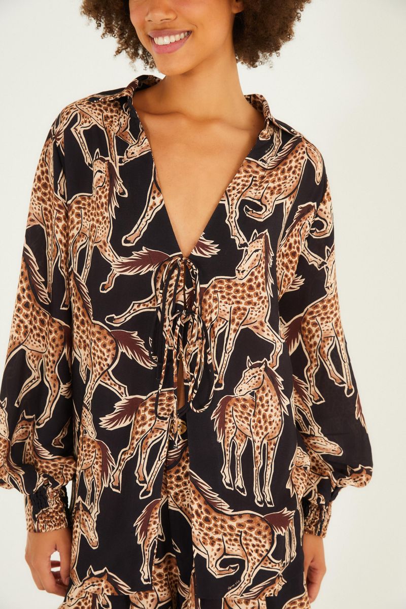 Detalle del cuello abierto y estampado de animales en la camisa.