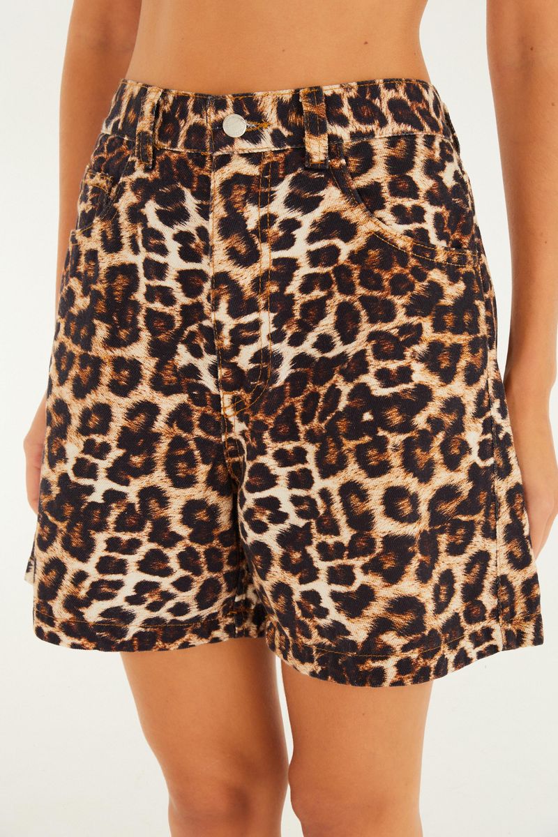 Vista frontal de cerca del bermuda de tela rígida con estampado de leopardo, mostrando detalles de la pretina y bolsillos.