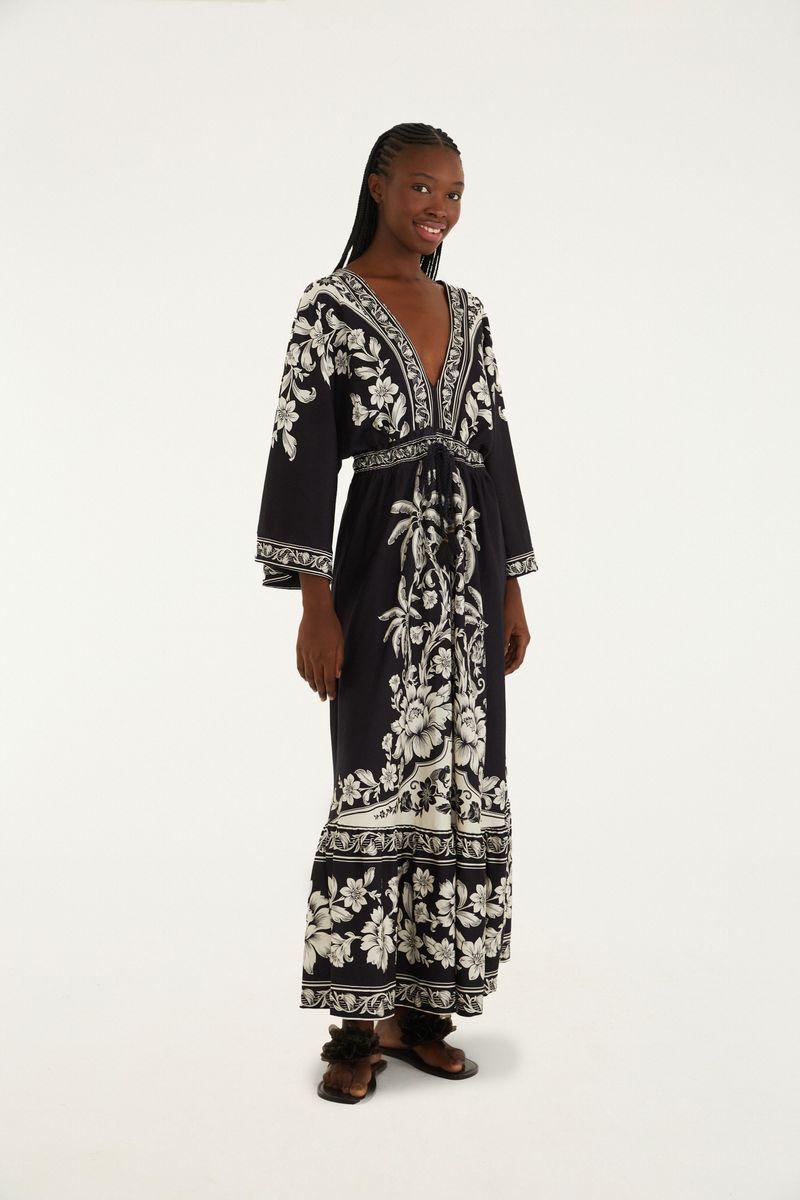 Vestido midi negro con estampado floral blanco, escote en V profundo y mangas largas.