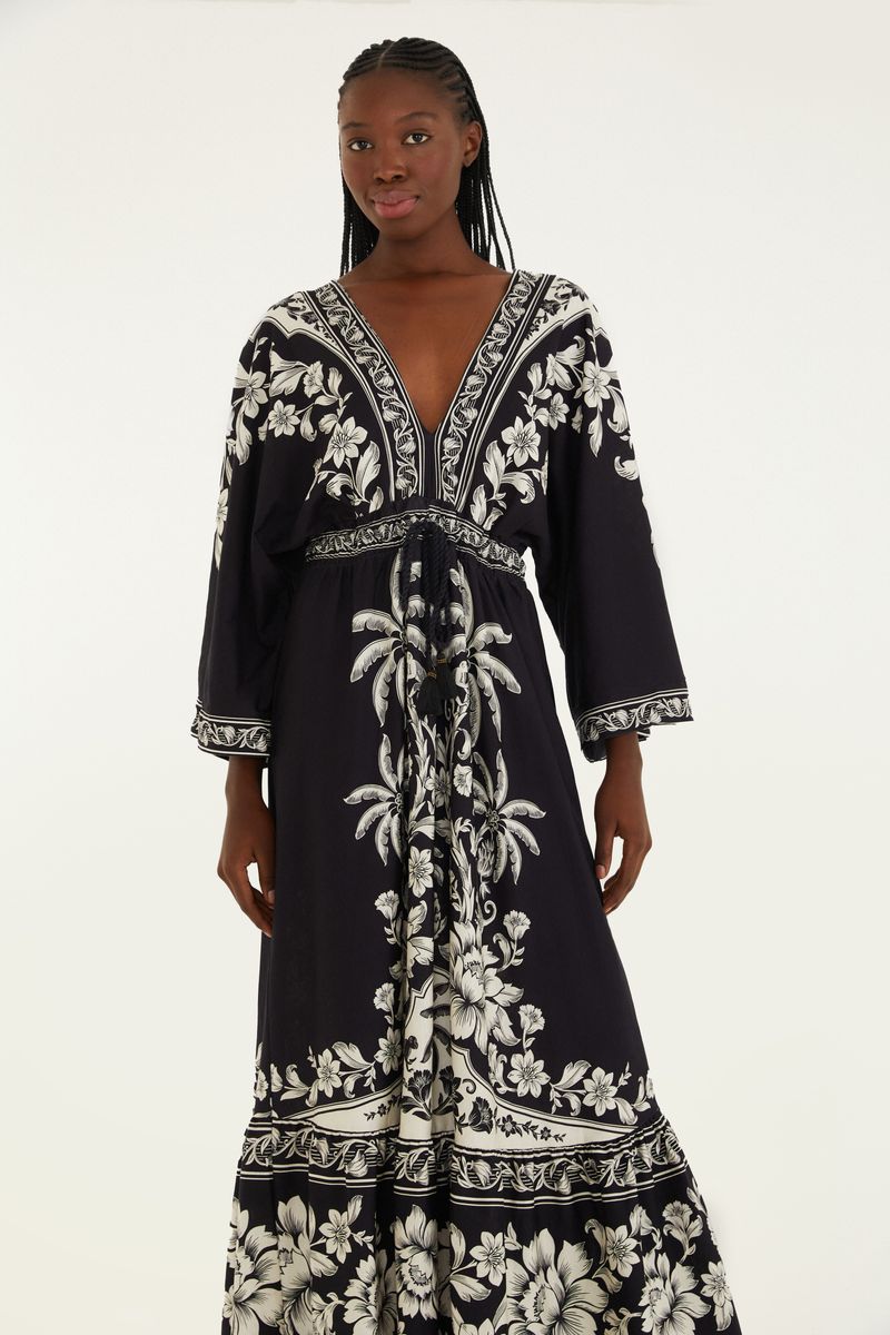 Vista frontal del vestido midi negro con estampado floral blanco, destacando el ajuste en la cintura.