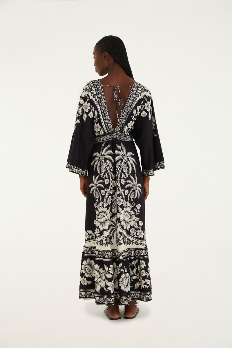 Vista trasera del vestido midi negro con estampado floral blanco, destacando el diseño de la falda.