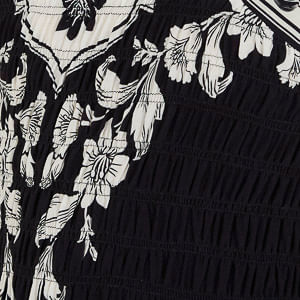 Primer plano del estampado botánico del vestido mostrando detalles florales y de follaje.