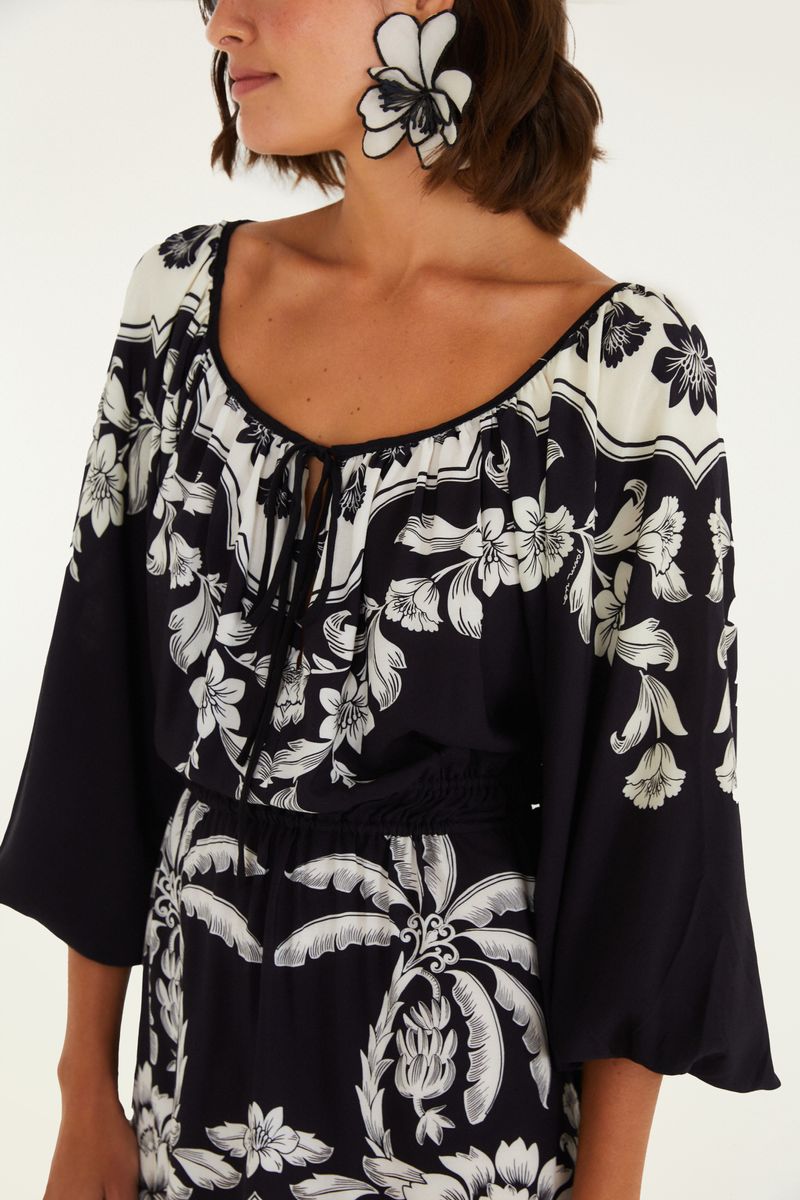 Detalle del cuello redondo con cordón y diseño floral en negro y blanco.