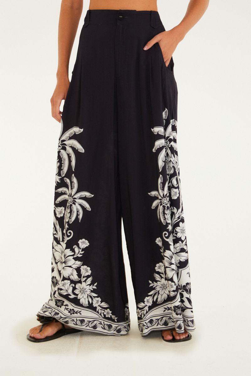 Detalle de la cintura del pantalón ancho negro con estampado tropical.
