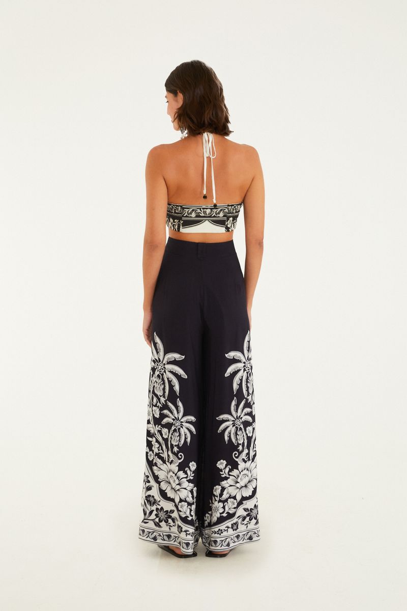 Vista trasera del pantalón ancho negro con estampado tropical.