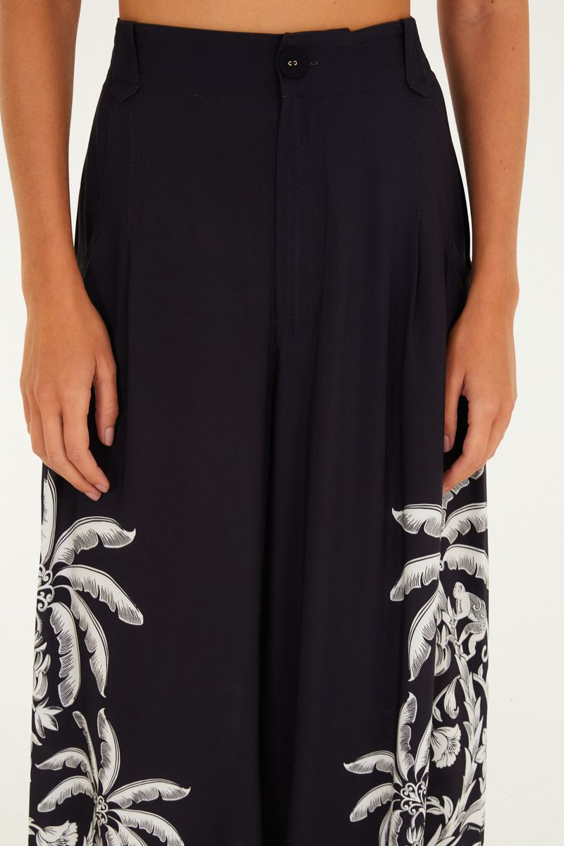 Acercamiento del estampado tropical en blanco en el pantalón ancho negro.