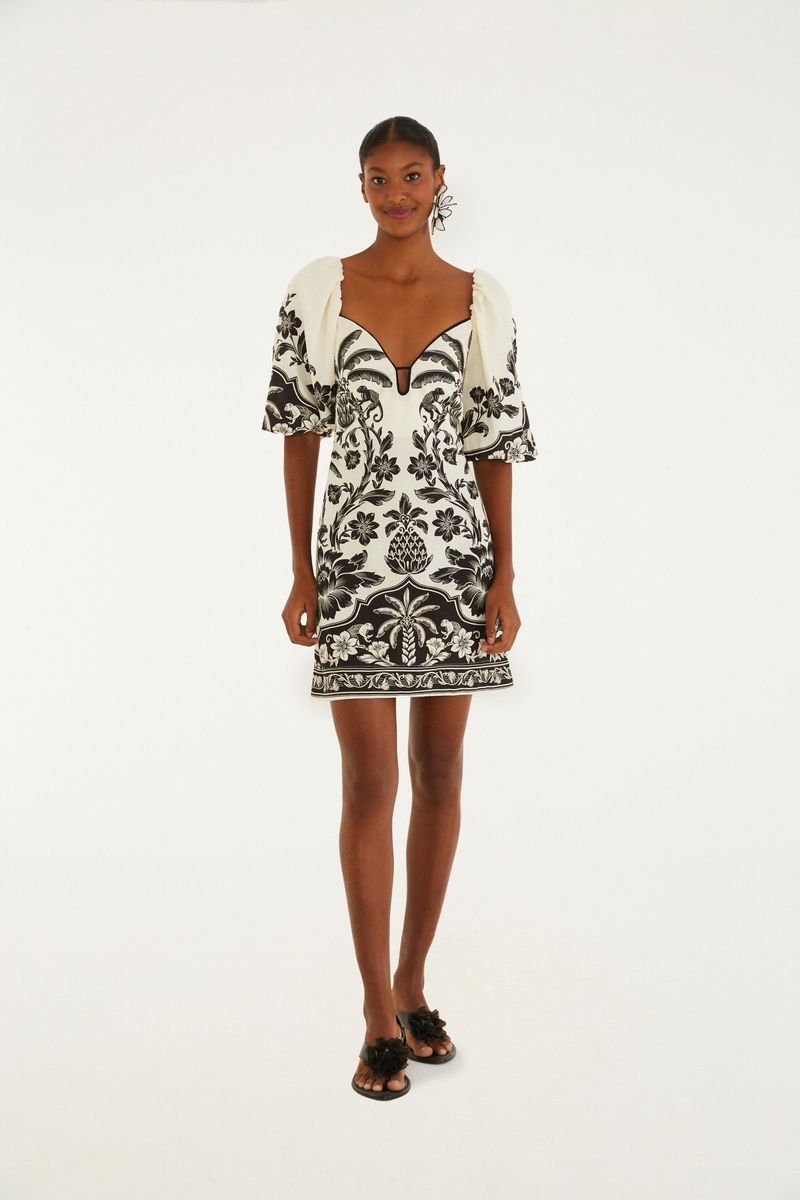 Vestido corto con estampado floral en blanco y negro, escote en V y mangas abullonadas.