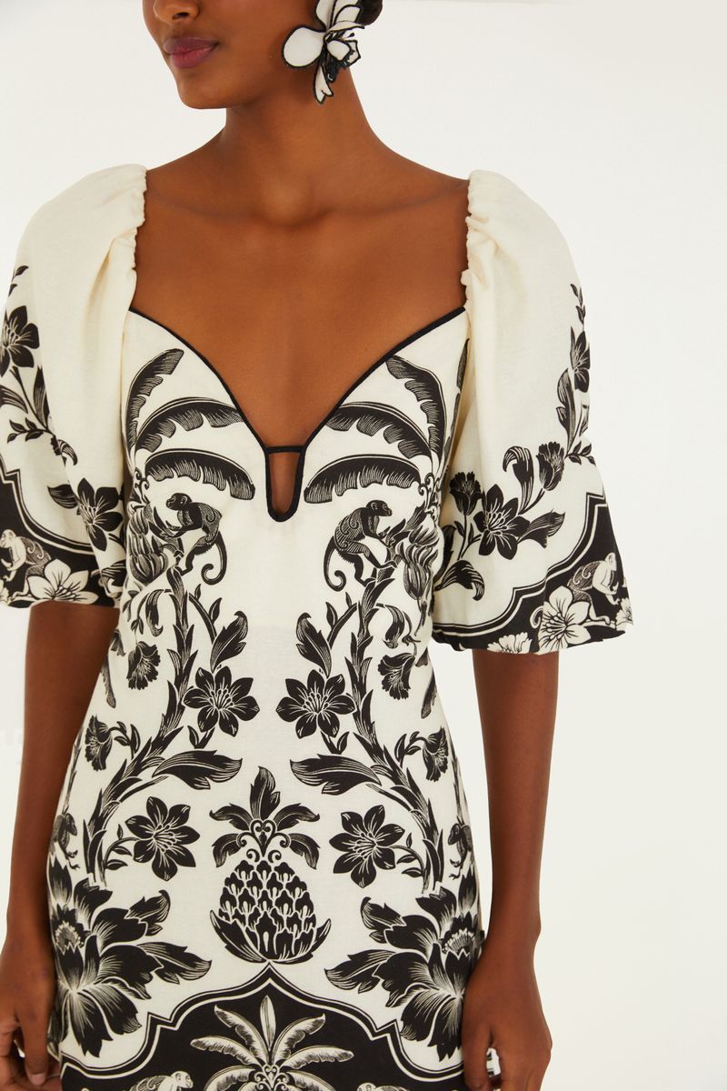 Detalle del escote en V del vestido corto con estampado floral en blanco y negro.