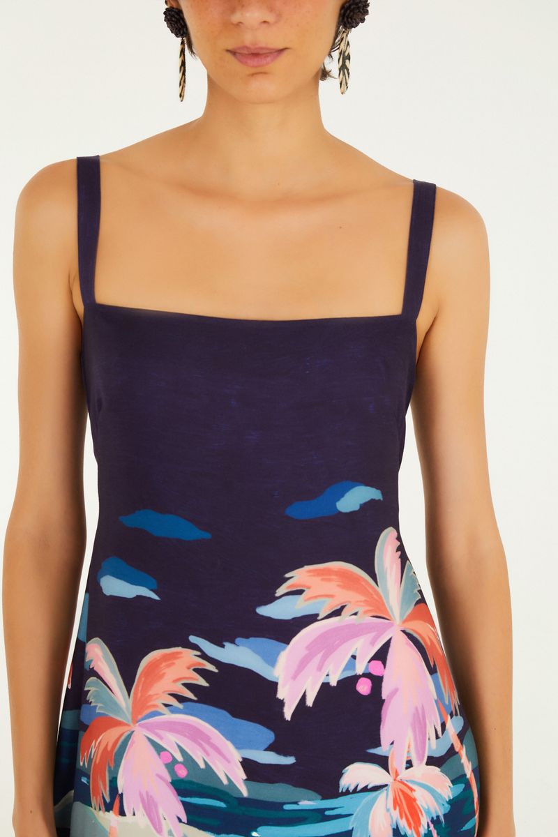 Acercamiento al escote cuadrado del vestido corto con estampado tropical.