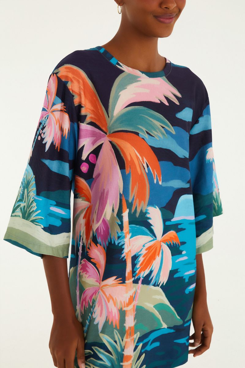 Vista lateral del vestido con estampado tropical, destacando el diseño de las mangas.