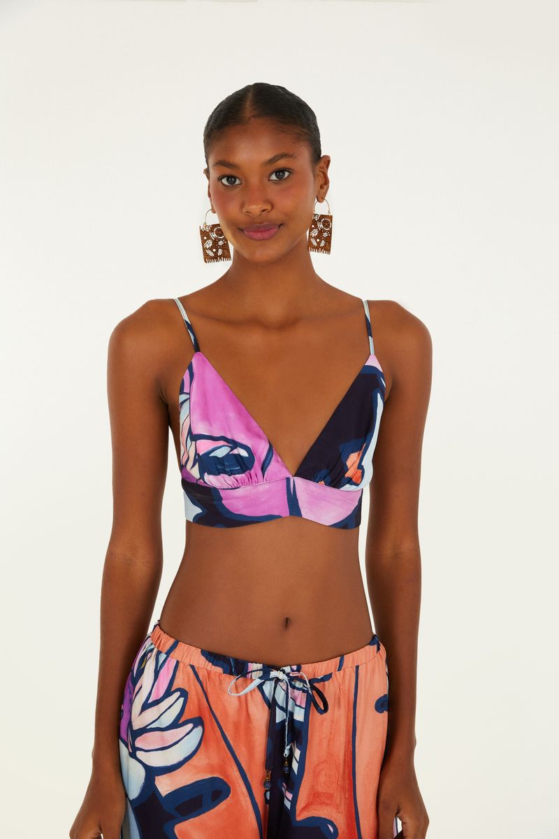 Imagen de un top estampado con diseño tropical en tonos vibrantes de rosa, azul y naranja, visto de frente.