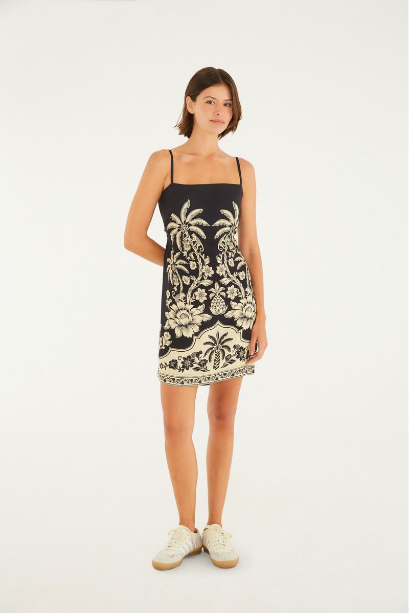 Vestido con tirantes delgados y estampado botánico sobre fondo negro, visto de cuerpo completo.