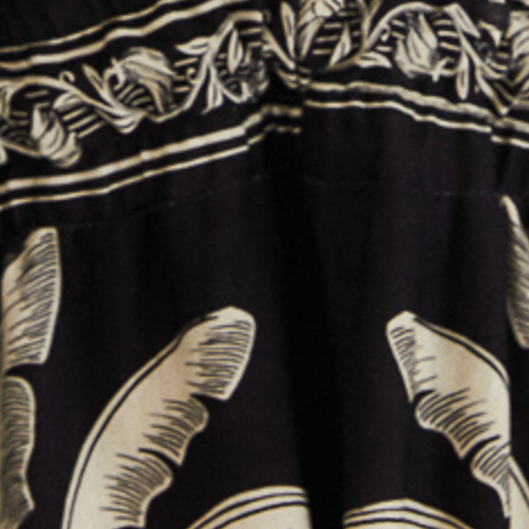 Primer plano del estampado floral blanco en el tejido negro del vestido midi.
