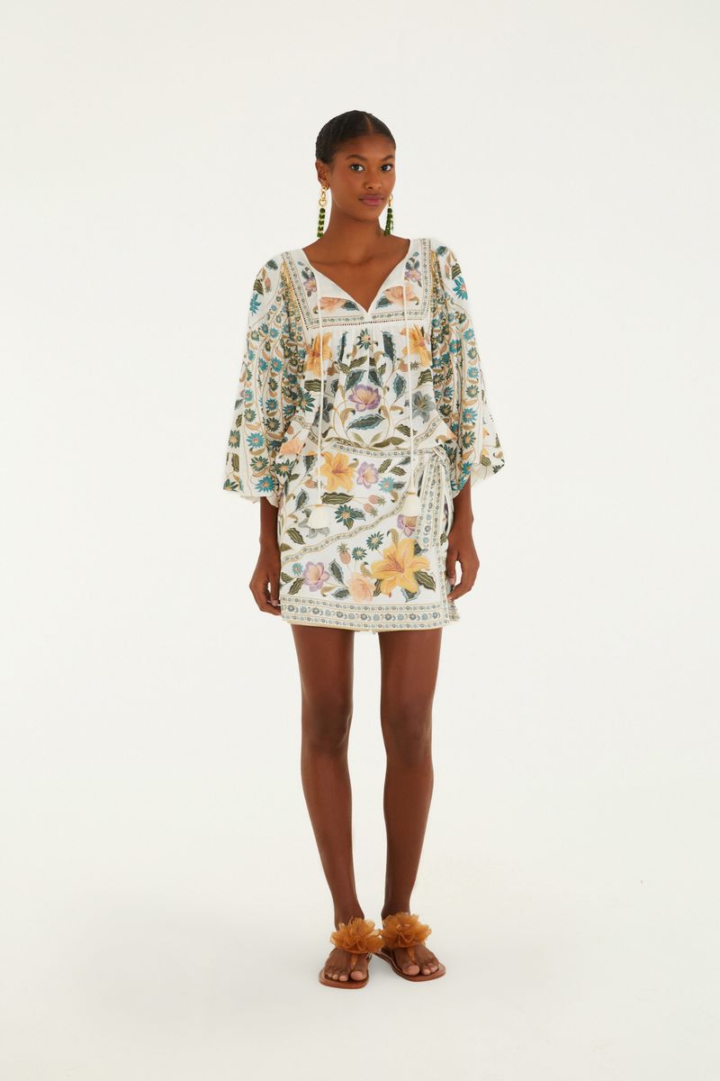 Modelo luciendo un short falda estampado con diseño floral vibrante y un lazo en la cintura.